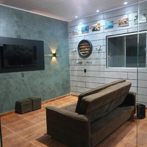 a living room with a couch and a flat screen tv at Chácara D Xavier in Marabá