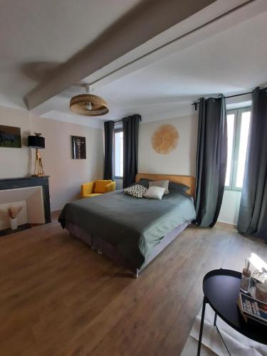 - une chambre avec un lit, un canapé et des fenêtres dans l'établissement Village-heart house with a Tropezian terrace, à Collobrières