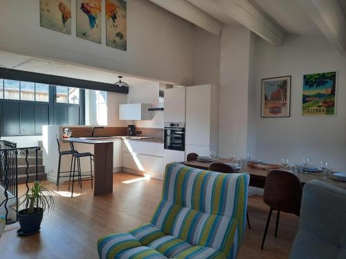 - un salon et une cuisine avec une chaise et une table dans l'établissement Village-heart house with a Tropezian terrace, à Collobrières