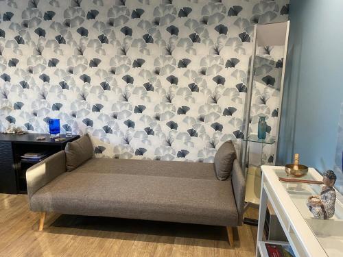 un canapé dans une pièce avec un mur de parapluies dans l'établissement House for your vacation or your colleagues, à Saint-André-des-Eaux