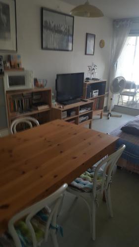 - une table en bois dans le salon avec une télévision dans l'établissement Sète entre Canaux, à Sète