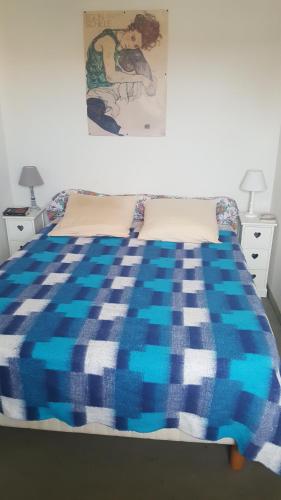 - un lit avec une couverture bleue et blanche dans l'établissement Sète entre Canaux, à Sète