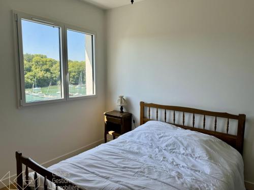 une chambre avec un lit et une fenêtre dans l'établissement Vieux Doëlan, à Clohars-Carnoët