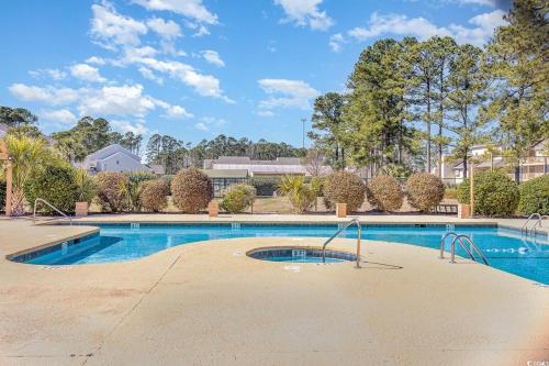 a swimming pool in a yard with trees at First floor, Little River Condo with Pool 3 miles from beach in Little River