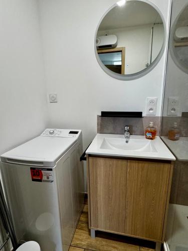 une petite salle de bain avec un lavabo et un miroir dans l'établissement Maison de ville proche CNPE et plage, à Grand-Fort-Philippe