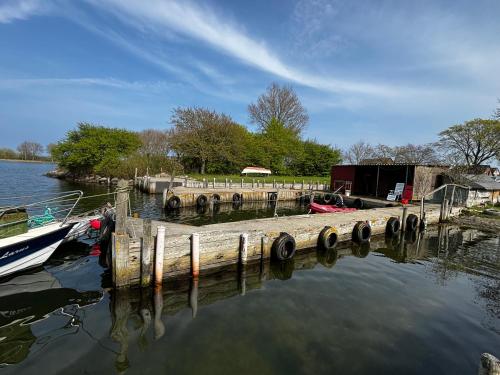 un muelle con un barco en un cuerpo de agua en Wohnung mit Kahnstelle, en Maasholm