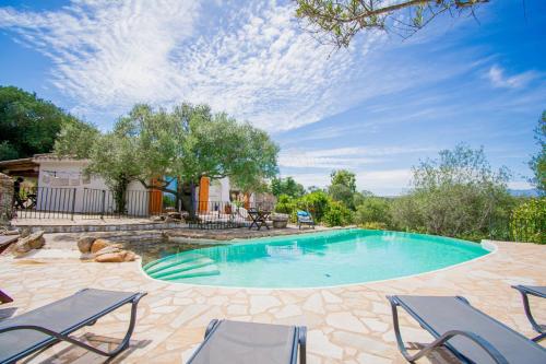 een zwembad in een tuin met stoelen bij Villa Mare è Macchia Accasà in Bonifacio