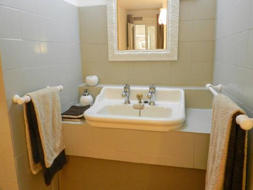 a bathroom with a sink and a mirror and towels at La Lavande in La Robine