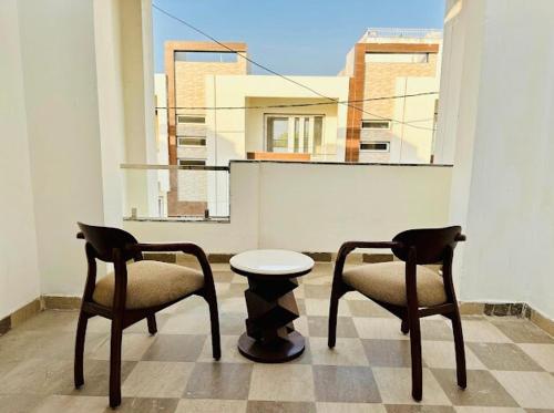 two chairs and a table in a room with a window at Ananda Tattva by Srijan Stays, Near Iskcon Temple in Vrindāvan