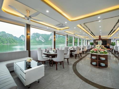 a restaurant with tables and chairs and a view of the water at Halong Collection Of The Sea Cruises in Ha Long