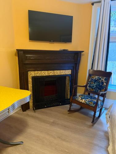 a living room with a fireplace with a television above it at Buffalo Guesthouse in Buffalo
