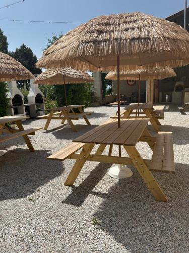 a group of picnic tables with a straw umbrella at Domaine Saladry in Villepinte