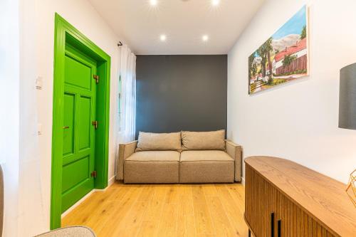 a green door in a living room with a couch at Pensiunea Casa Weiss in Rimetea
