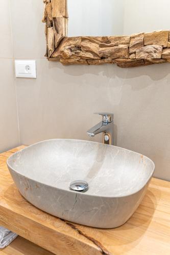a bathroom with a large bowl sink on a wooden counter at Pensiunea Casa Weiss in Rimetea