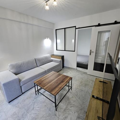 un salon avec un canapé et une table basse dans l'établissement Idéal Central Calme Cosy Chaleureux Zen Appartement Mignon, à Nice