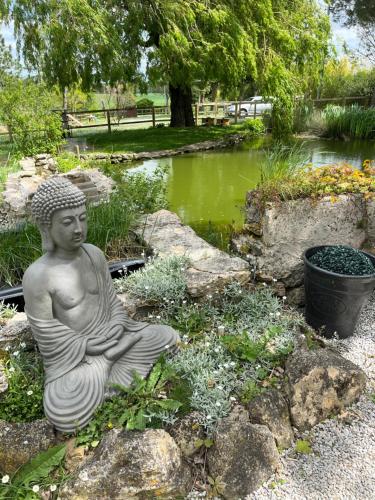 a statue of a buddha sitting in a garden at Domaine Saladry in Villepinte