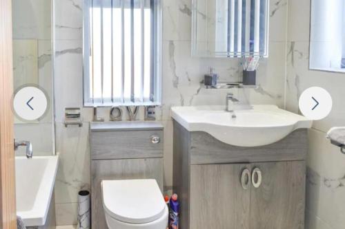 a bathroom with a sink and a toilet and a mirror at The hawthorns large detached 3 bedroom family home in Seaham