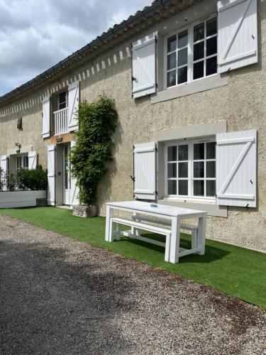 a white bench sitting in front of a house at Domaine Saladry in Villepinte