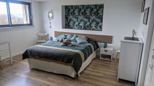 une chambre avec un lit sur lequel est allongé un chien dans l'établissement Domaine de la Griffe - Chambres d'hôtes 