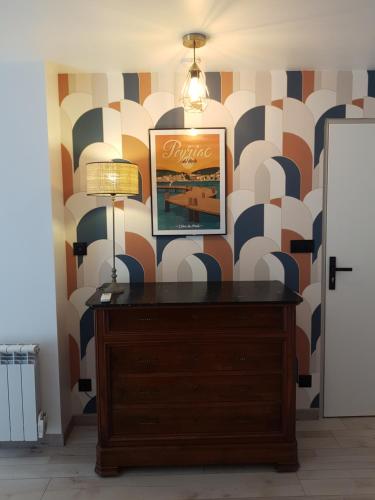 une pièce avec une commode avec un tableau sur un mur dans l'établissement gite de l'ille, à Peyriac-de-Mer