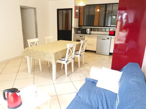 une cuisine avec une table et des chaises dans une pièce dans l'établissement gite de l'ille, à Peyriac-de-Mer