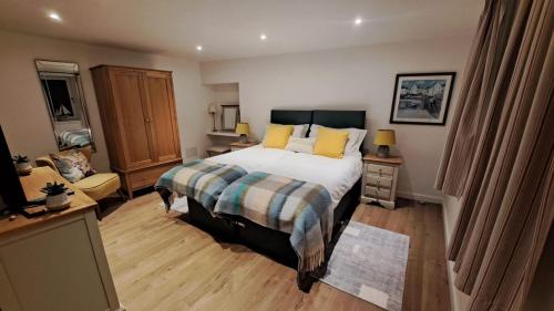 a bedroom with a large bed with yellow pillows at SEASIDE HOUSE 12 Shore Street, Avoch IV9 8QD in Avoch