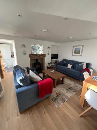 a living room with two blue couches and a table at SEASIDE HOUSE 12 Shore Street, Avoch IV9 8QD in Avoch