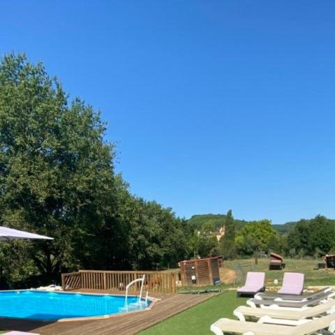 - une piscine avec des chaises longues et une terrasse dans l'établissement La Bergerie Luxury cottage and pool on eco-friendly micro-farm, à Duravel