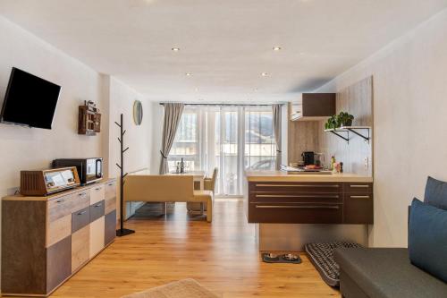 a living room with a kitchen and a dining room at Apart Gabl in Fliess