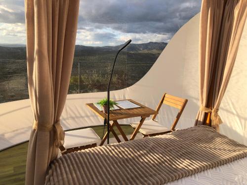 a bedroom with a bed and a table with a view at Cabañas De Madera Y Bungalows - Gilmañas 3 in La Iruela