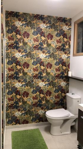 La salle de bains est pourvue de toilettes et de papier peint à fleurs. dans l'établissement Maison bourgeoise Vue Mer 600m de la grande plage, à Saint-Cast-le-Guildo