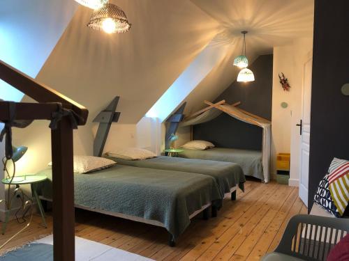 deux lits dans une chambre avec un grenier dans l'établissement Maison bourgeoise Vue Mer 600m de la grande plage, à Saint-Cast-le-Guildo