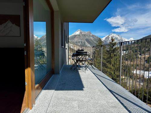 a balcony with a table and a view of mountains at Vista sulle Alpi in Valdidentro