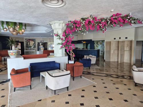 a lobby with chairs and tables and flowers at Golf Residence- Families and Couples Only in Hammam Sousse