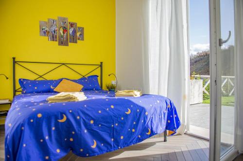a bed with a blue comforter in a bedroom at Le Anfore - Puntone di Scarlino in Dogana