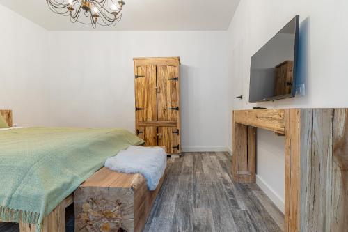 a bedroom with a bed and a tv on a wall at Pensiunea Casa Weiss in Rimetea