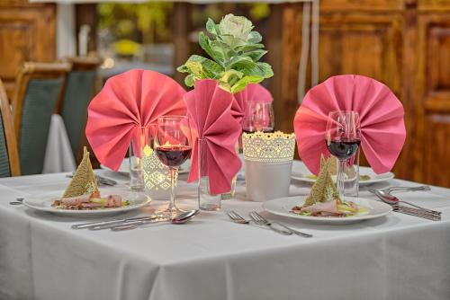 a table with plates of food and glasses of wine at Hotel Kamieniczka in Legnica