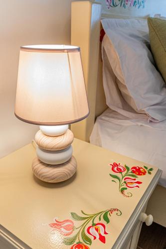a lamp on a table next to a bed at Pensiunea Casa Weiss in Rimetea