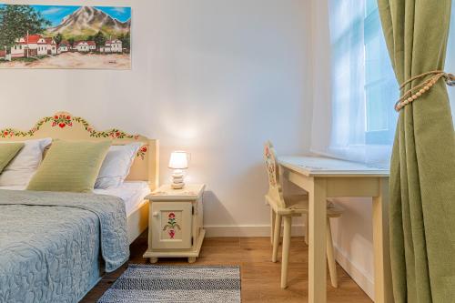 a bedroom with a bed and a desk and a window at Pensiunea Casa Weiss in Rimetea
