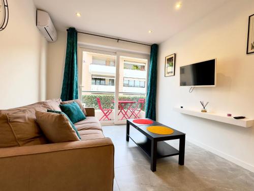 un salon avec un canapé et une table dans l'établissement Le Versailles By SCLS Locations, à Cannes