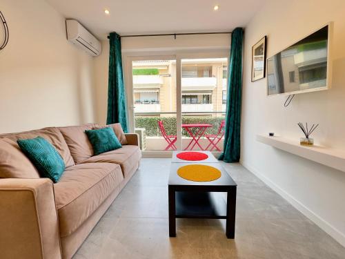 un salon avec un canapé et une table dans l'établissement Le Versailles By SCLS Locations, à Cannes