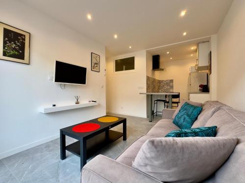 un salon avec un canapé et une table dans l'établissement Le Versailles By SCLS Locations, à Cannes