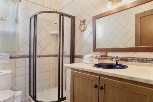 a bathroom with a shower and a sink and a mirror at Preciosa casa en Conil in Conil de la Frontera