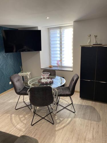 a dining room with a glass table and chairs at Résidence du lion d'or in Conflans