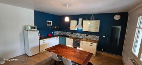 une cuisine avec une table en bois et un réfrigérateur blanc dans l'établissement Country House, à Lafrançaise