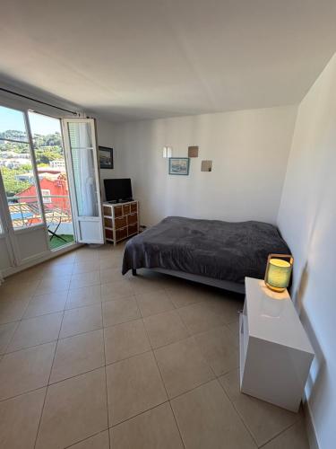 une chambre avec un lit et un balcon dans l'établissement Appartement centre du village, à Cassis