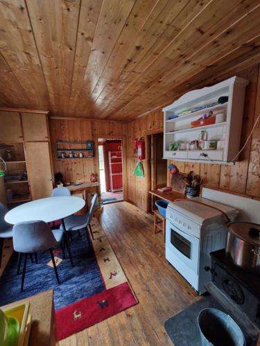 a kitchen with a table and a white stove at Hytte uten hyttenaboer in Nore