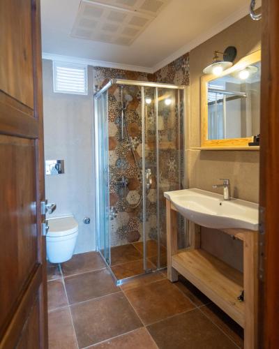 a bathroom with a shower and a sink and a toilet at Casa Caria Suites in Bodrum City