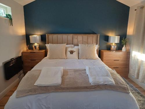a bedroom with a large bed with white sheets and pillows at The Beehive Inn in Bury Saint Edmunds