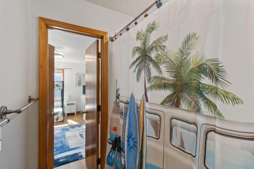 Una habitación con una furgoneta con una palmera en la pared. en Waz Up Beaches, en Sanderling